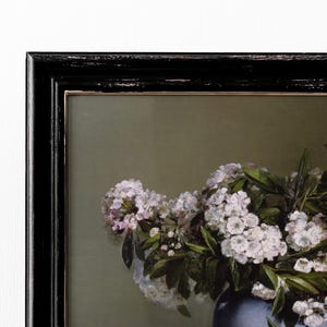 May include: A framed painting of a bouquet of white flowers in a blue vase. The flowers are arranged in a loose, natural style, and the vase is simple and elegant.