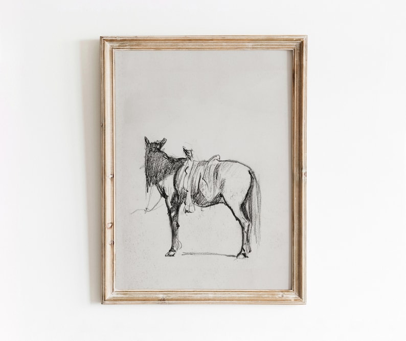 May include: A black and white pencil drawing of a horse with a saddle on its back, framed in a light wood frame.