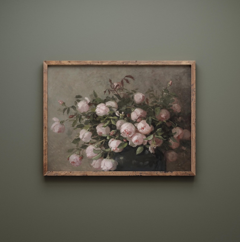 May include: A framed vintage-style print featuring a bouquet of pink roses in a dark vase. The artwork has a muted color palette with a distressed, aged appearance. The wooden frame adds a rustic touch.