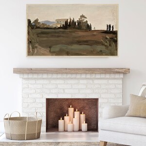 May include: A white brick fireplace with a wooden mantel and a brown hearth. There are several white pillar candles lit inside the fireplace. A white armchair with a beige throw pillow is in the foreground. A wicker basket is on the floor in front of the fireplace.