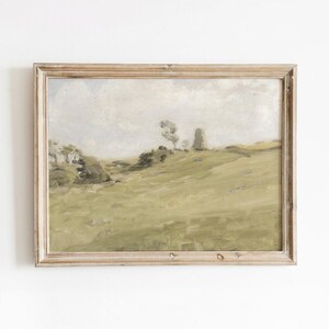 May include: A framed painting depicting a landscape with rolling hills, a few trees, and a cloudy sky. The painting is executed in muted greens and browns.