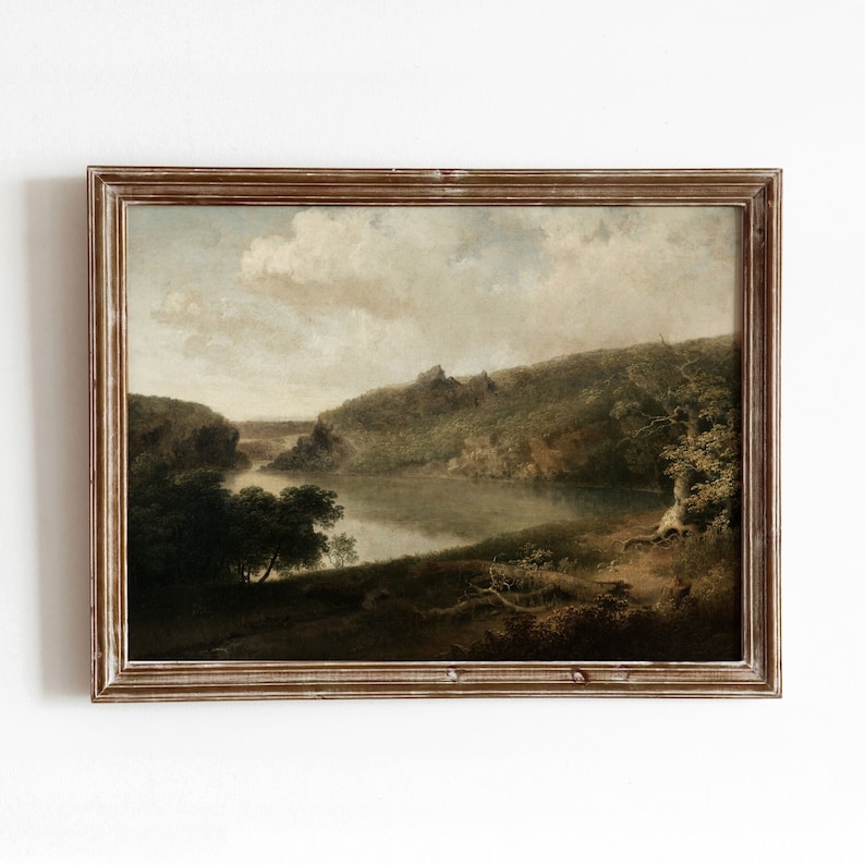 May include: A framed landscape painting depicting a river winding through a lush green valley. The sky is a soft blue with fluffy white clouds. The painting is in a brown wooden frame.