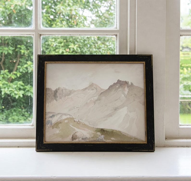 May include: A framed watercolor painting depicting a mountain range with a light brown and gray color scheme. The mountains are depicted in a realistic style with a focus on the peaks and valleys.