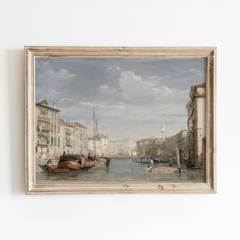 K&ouml;nnte beinhalten: Ein Vintage-Gem&auml;lde in einem Holzrahmen zeigt eine Kanalszene in Venedig, Italien. Das Gem&auml;lde zeigt einen Wasserweg, der von Geb&auml;uden, Booten und Menschen ges&auml;umt ist. Der Himmel ist hellblau mit wei&szlig;en Wolken.