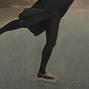 May include: A close-up of a person's leg wearing black tights and brown leather ice skates. The person is skating on a grey ice surface.