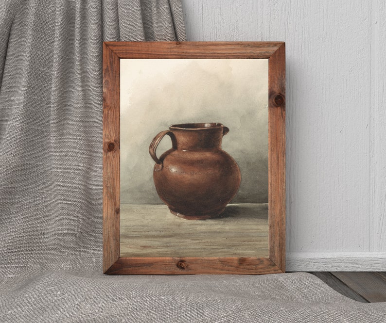 May include: A watercolor painting of a brown ceramic pitcher in a wooden frame. The pitcher has a rounded body and a wide mouth.