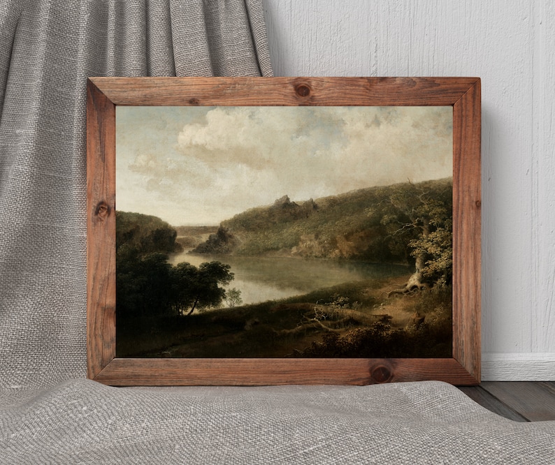 May include: A framed landscape painting depicting a river winding through a lush green forest. The sky is a soft blue with fluffy white clouds. The painting is in a rustic wooden frame.