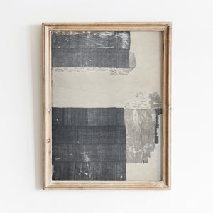 May include: A framed abstract art print with a beige background and black and gray geometric shapes. The frame is made of wood and has a light brown finish.