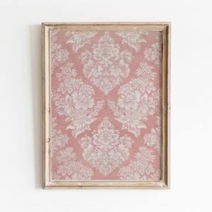 May include: A framed print of a pink and white damask pattern. The frame is a light wood colour with a distressed finish.
