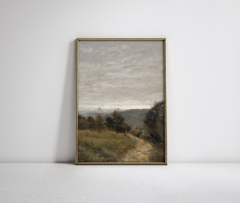 May include: A framed painting of a landscape with a dirt road leading through a forest. The sky is cloudy and gray, and the trees are a mix of green and brown.