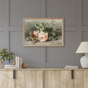 May include: A framed painting of a bouquet of pink roses with green leaves and stems against a light brown background.