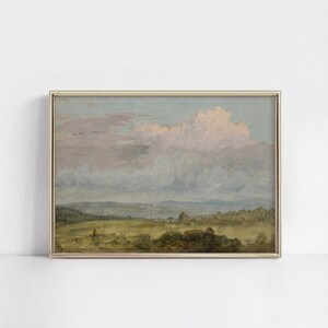 May include: A framed painting of a landscape with a large, fluffy cloud in the sky. The sky is a soft blue and pink, and the landscape is a green field with trees in the distance.