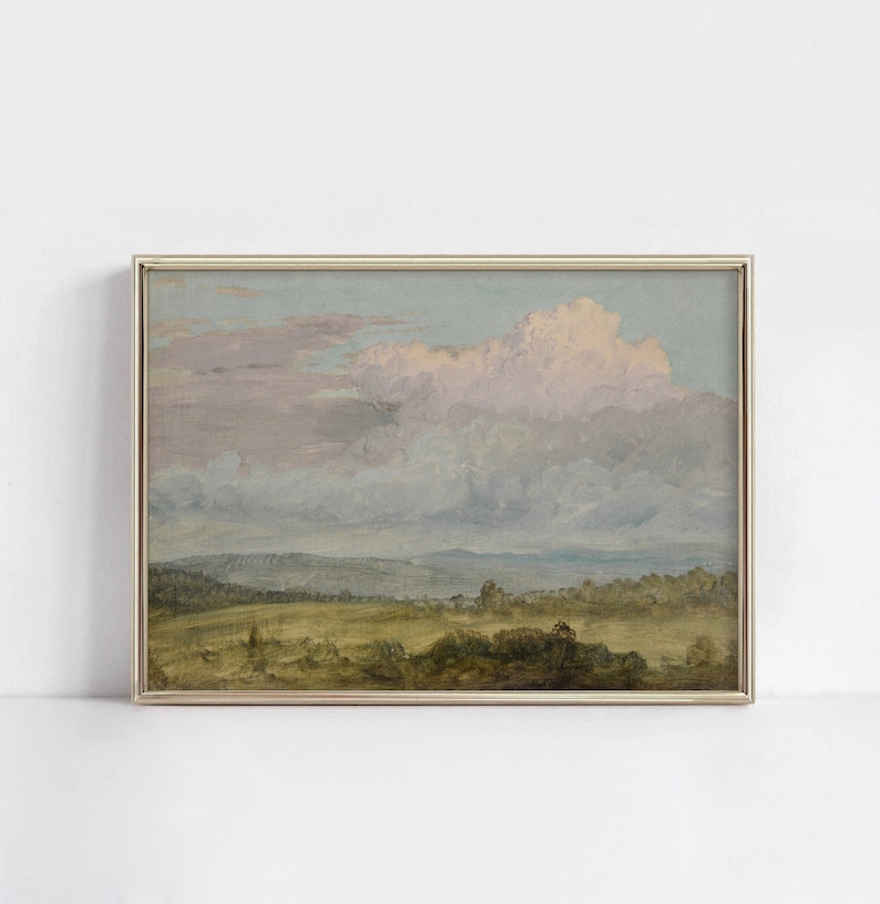 May include: A framed painting of a landscape with a large, fluffy cloud in the sky. The sky is a soft blue and pink, and the landscape is a green field with trees in the distance.