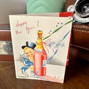 Tarjeta de Año Nuevo y sobre imprimibles con un bebé vintage con sombrero de copa y de pie abrazando una botella de champán Descarga digital