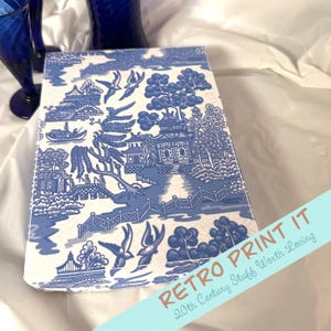 May include: A blue and white box with a traditional Chinese pattern. The box is decorated with a repeating pattern of birds, trees, and a pagoda. The text "Retro Print It 20th Century Stuff Worth Loving" is printed on the box.