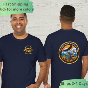 Könnte beinhalten: Marineblaues T-Shirt mit einem goldenen Logo auf der Vorderseite, das "Anytime, Anywhere" lautet. Die Rückseite des Shirts hat ein großes, farbenfrohes Logo mit der Aufschrift "Undersea Special Mission Systems".