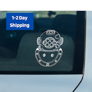 May include: A white outline drawing of a vintage diving helmet on a dark blue car window.