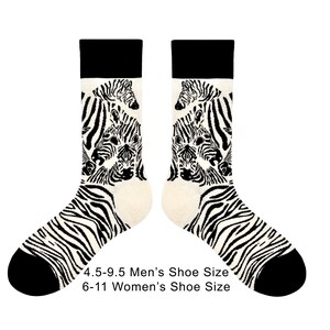 May include: Pair of socks with a zebra pattern. The socks have a black cuff, heel, and toe, with a cream-coloured foot and leg. The leg of the sock features a zebra face design. The text on the image reads: 4.5-9.5 Men's Shoe Size 6-11 Women's Shoe Size.