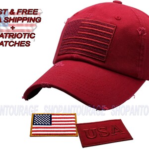 May include: Red baseball cap with a distressed look and an embroidered American flag on the front. The cap also has a small embroidered "USA" patch on the side.