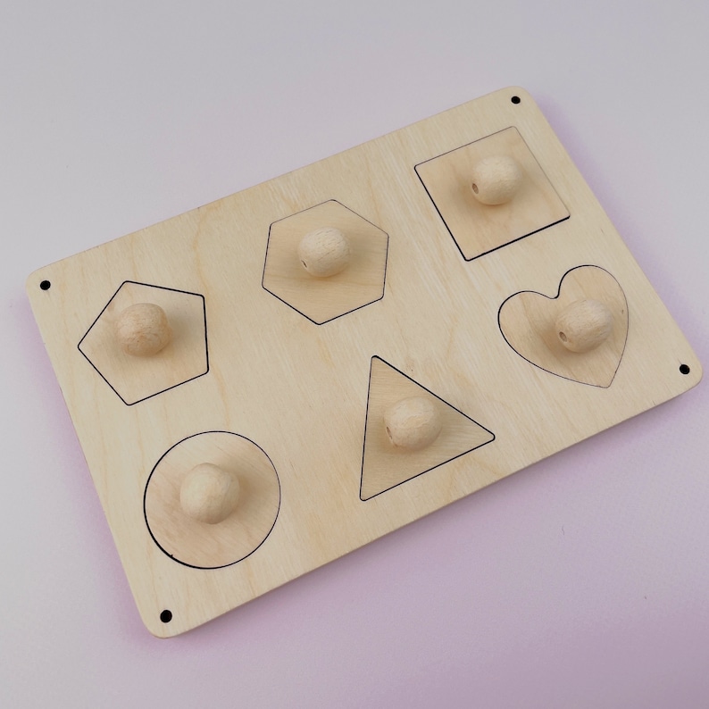 Puede incluir: Juguete de madera con seis formas diferentes: c&iacute;rculo, cuadrado, coraz&oacute;n, pent&aacute;gono, hex&aacute;gono y tri&aacute;ngulo. Cada forma tiene una perilla de madera en el centro.