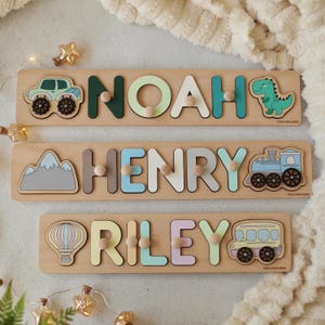 May include: Wooden name puzzles with colorful letters and transportation-themed illustrations. Each puzzle spells a name: Noah, Henry, and Riley. The puzzles feature a car, dinosaur, mountain, train, hot air balloon, and bus.