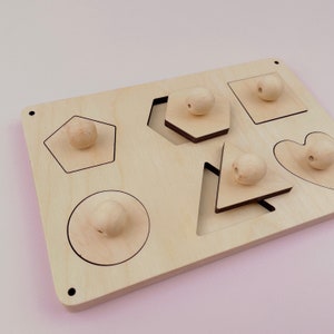 Puede incluir: Juguete de madera de clasificaci&oacute;n de formas con seis formas diferentes: un c&iacute;rculo, un cuadrado, un coraz&oacute;n, un pent&aacute;gono, un hex&aacute;gono y un tri&aacute;ngulo. Cada forma tiene una perilla de madera correspondiente.