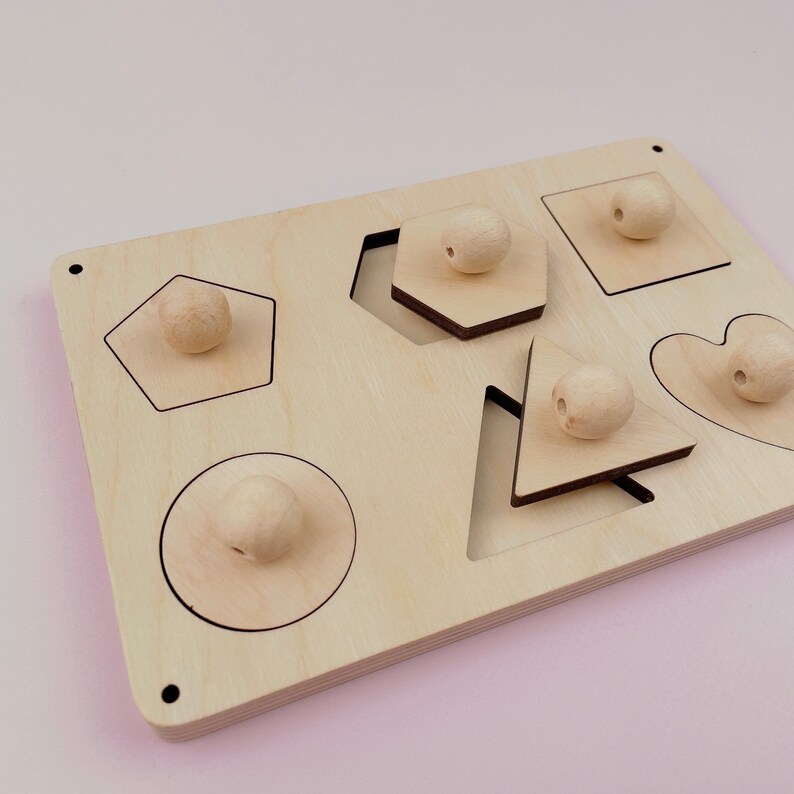 Puede incluir: Juguete de madera de clasificaci&oacute;n de formas con seis formas diferentes: un c&iacute;rculo, un cuadrado, un coraz&oacute;n, un pent&aacute;gono, un hex&aacute;gono y un tri&aacute;ngulo. Cada forma tiene una perilla de madera correspondiente.