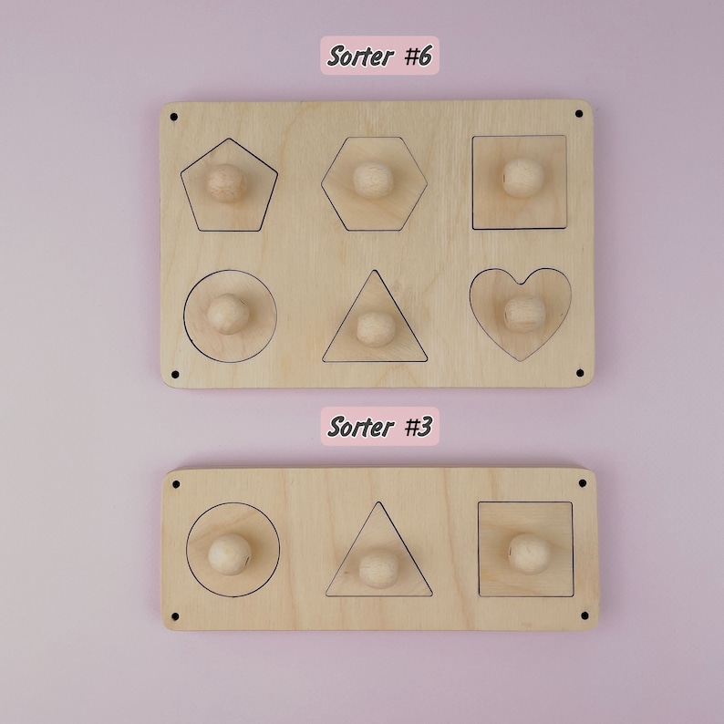 Puede incluir: Dos clasificadores de formas de madera. El clasificador superior tiene seis formas: un pent&aacute;gono, un hex&aacute;gono, un cuadrado, un c&iacute;rculo, un tri&aacute;ngulo y un coraz&oacute;n. El clasificador inferior tiene tres formas: un c&iacute;rculo, un tri&aacute;ngulo y un cuadrado. Cada forma tiene una peque&ntilde;a perilla de madera en el centro.