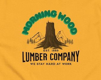 May include: A yellow t-shirt with a green and black logo that says "Morning Wood Lumber Company Est. 1889 We Stay Hard At Work". The logo features a large tree stump with mountains in the background.