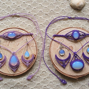 Könnte beinhalten: Zwei Sets Opal-Schmuck mit lila Makramee-Schnur. Jedes Set enthält eine Halskette, ein Armband und Ohrringe. Die Opale sind hellblau mit einem Regenbogen-Schimmer.