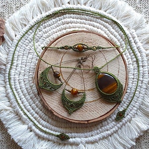 May include: A set of green macrame jewelry with tiger's eye stones. The set includes a necklace, a bracelet, and a pair of earrings.