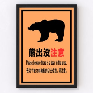 Peut inclure: Affiche encadrée avec une silhouette d'ours noir sur fond orange. Le poster contient du texte en chinois et en anglais, avertissant de la présence d'ours. Le cadre est noir.