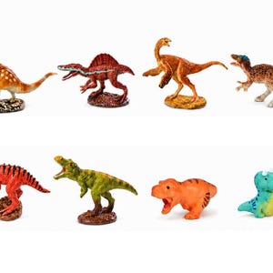May include: A collection of eight small dinosaur figurines in various poses and colours, including orange, red, green, and blue. The set features diverse species with textured skin details, standing on individual bases or flat surfaces.