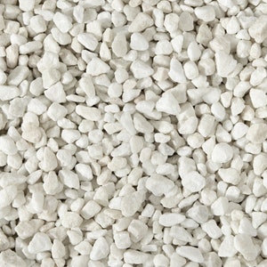May include: A close-up view of white marble gravel. The gravel is small and uniform in size, with a smooth, polished finish.