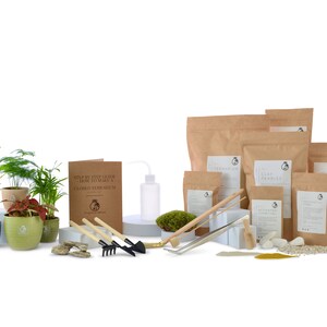 K&ouml;nnte beinhalten: Ein Terrarien-Set mit allem, was Sie brauchen, um Ihr eigenes geschlossenes Terrarium zu erstellen. Das Set enth&auml;lt eine Vielzahl von Pflanzen, Erde, Moos, Steine und Werkzeuge. Das Set enth&auml;lt auch ein B&uuml;chlein mit Schritt-f&uuml;r-Schritt-Anleitungen zur Herstellung eines Terrariums.