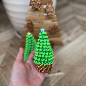 The Small Christmas tree sits on a wooden desk, shown as a fidget toy for focus.