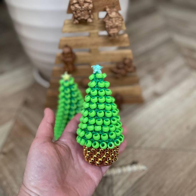 The Small Christmas tree sits on a wooden desk, shown as a fidget toy for focus.