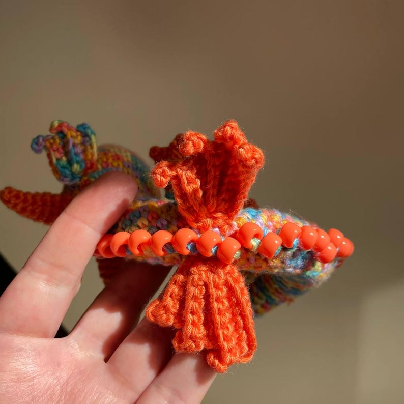 Top-down view of a finished sensory dragon highlighting the beaded crest along the spine, with beads evenly spaced and secured.