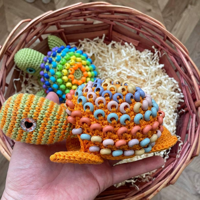 Crochet turtle next to wooden Montessori rainbow toy for scale