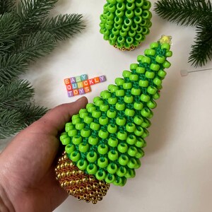 A green crochet Christmas tree with a textured surface made from pony beads