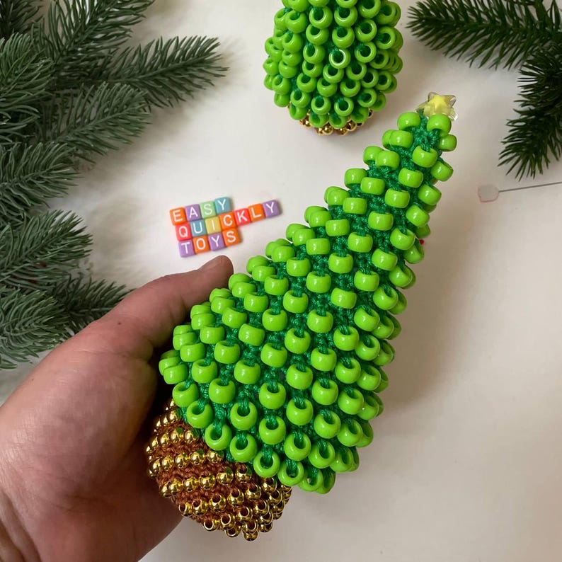 A green crochet Christmas tree with a textured surface made from pony beads