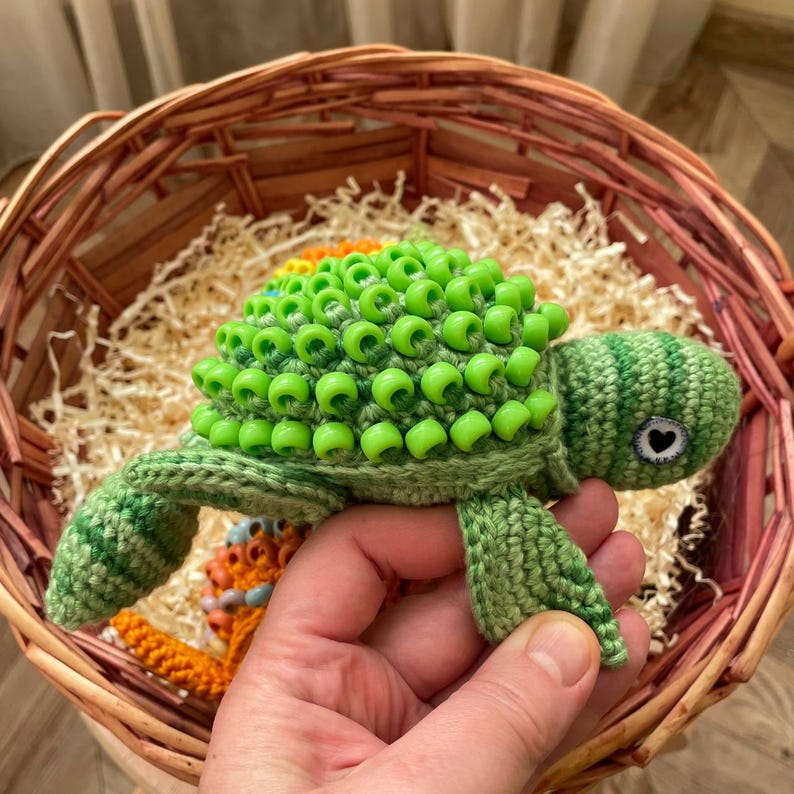 Green sensory toy turtle with head hidden inside shell