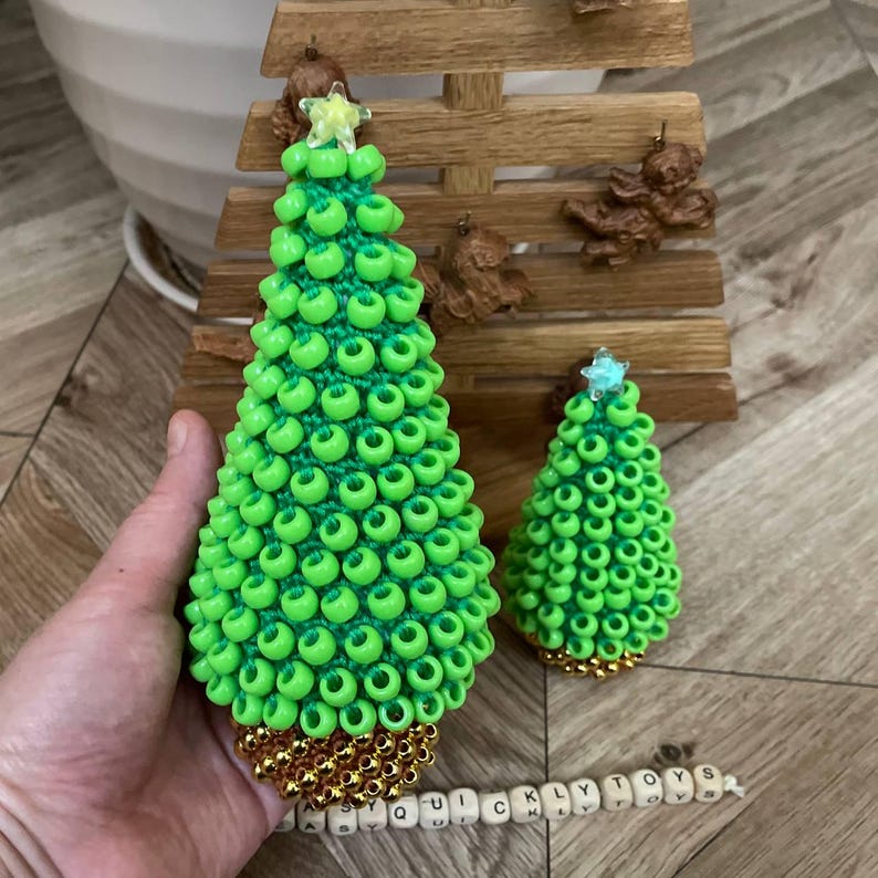 The crochet tree hanging from a branch as a festive holiday ornament