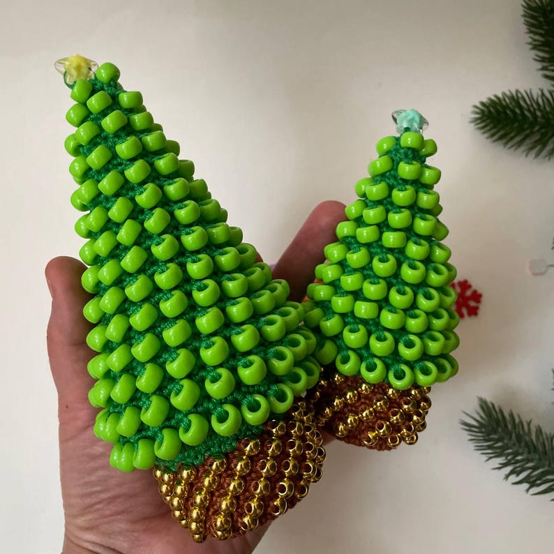 The beaded Christmas tree next to a laptop, positioned as a desk toy for stress relief
