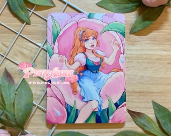 May include: A rectangular art print featuring a digital illustration of a character with long orange hair, wearing a blue dress with puffed sleeves, seated inside a large pink flower. The text PinkAshe and www.pinkashe.com is printed on the left.