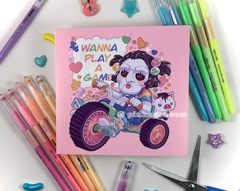 May include: A pink and white illustrated card with a cartoon character holding a knife and riding a toy car. The text on the card reads "Wanna Play a Game".
