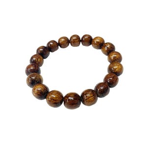 May include: A wooden bead bracelet featuring round, dark brown beads with visible wood grain. The beads are strung together to form a circular shape, suitable for wrist wear. The bracelet is displayed against a white background.