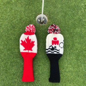 May include: Two knitted golf club head covers. One is red, white, and black with a Canadian flag design. The other is white, black, and red with a triathlon logo.