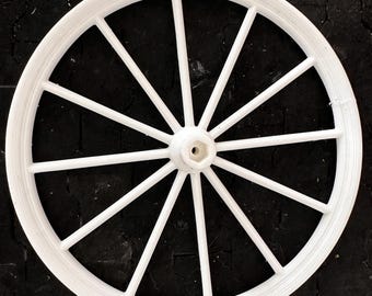 Puede incluir: Una rueda de carro de madera blanca con 12 radios.