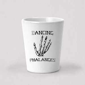 Puede incluir: Un vaso de chupito de cerámica blanca con un gráfico de mano de esqueleto negro y el texto "Dancing Phalanges".